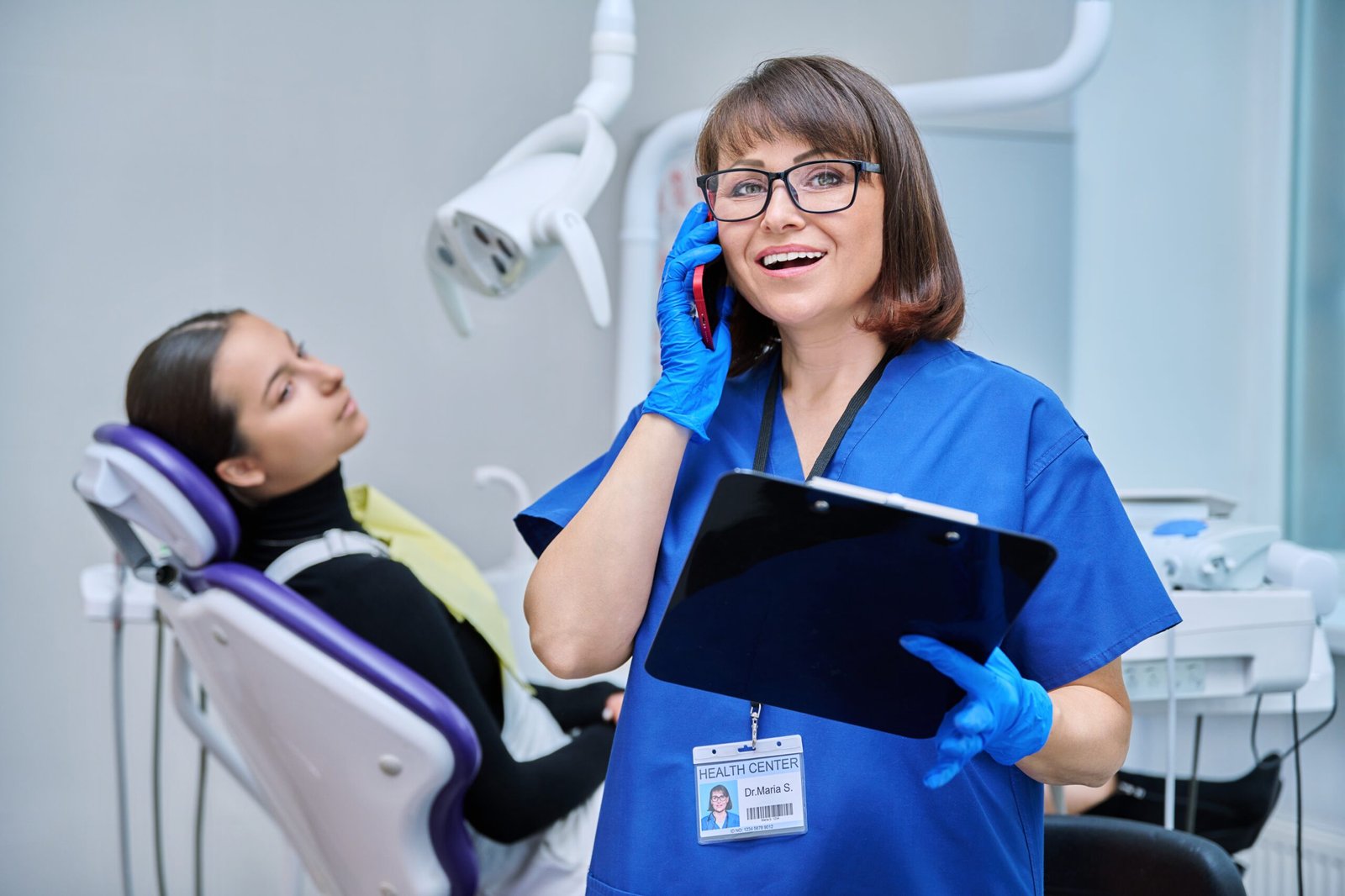 Dentist doctor nurse in the office talking on the phone.