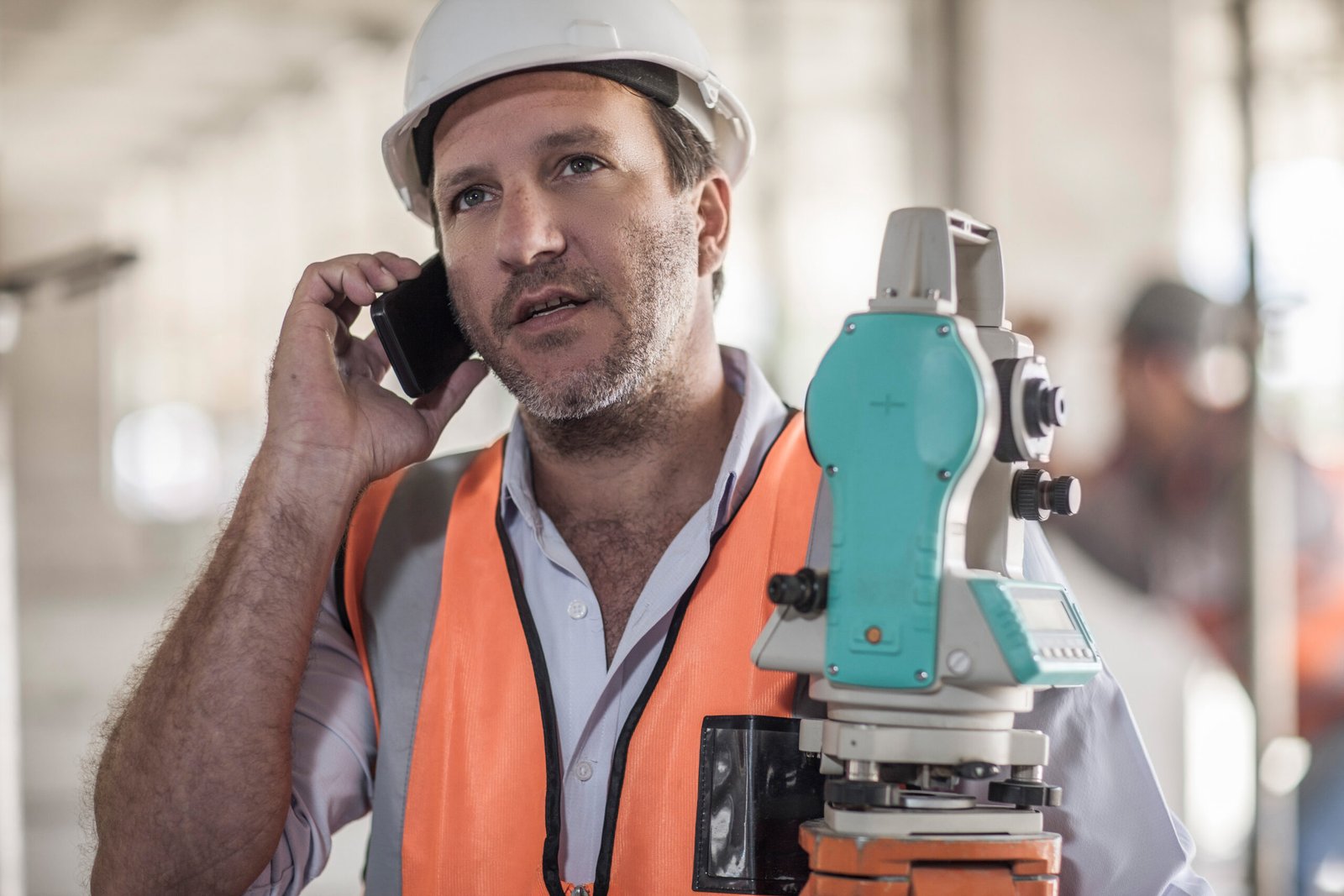 Surveyor talking on smartphone on construction site